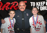 Picture of officer with two Dare program students 
